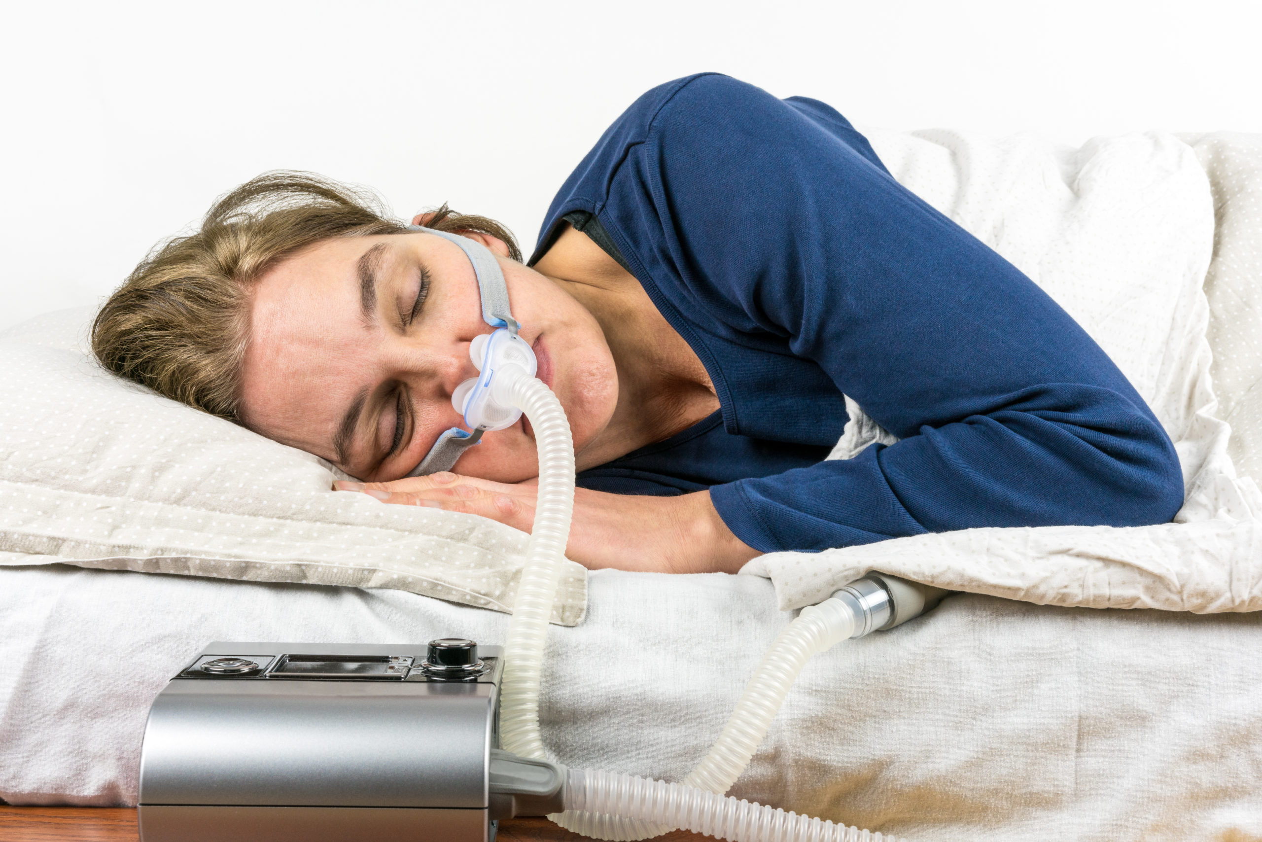 Woman using a CPAP to treat obstructive sleep apnea