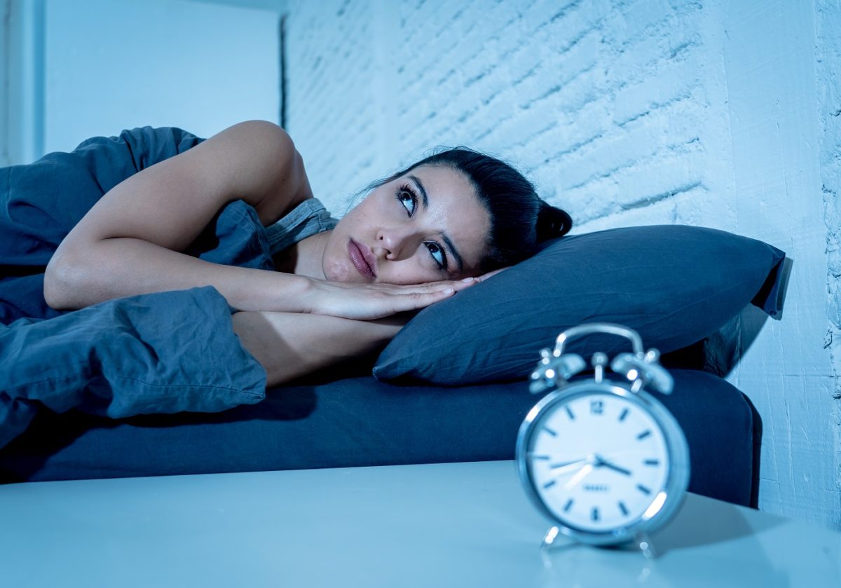 Woman with insomnia wondering how many hours of sleep she needs